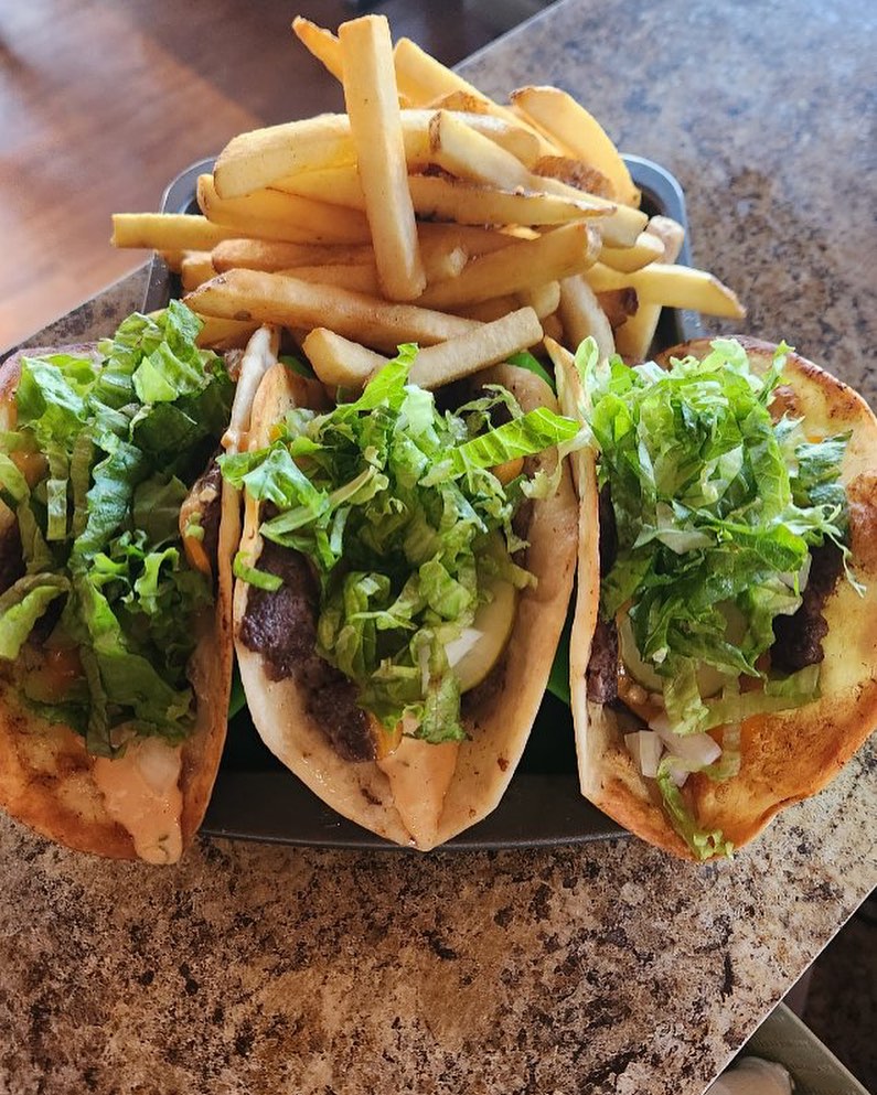 Three Burger Smash Tacos in a row with fries on the plate