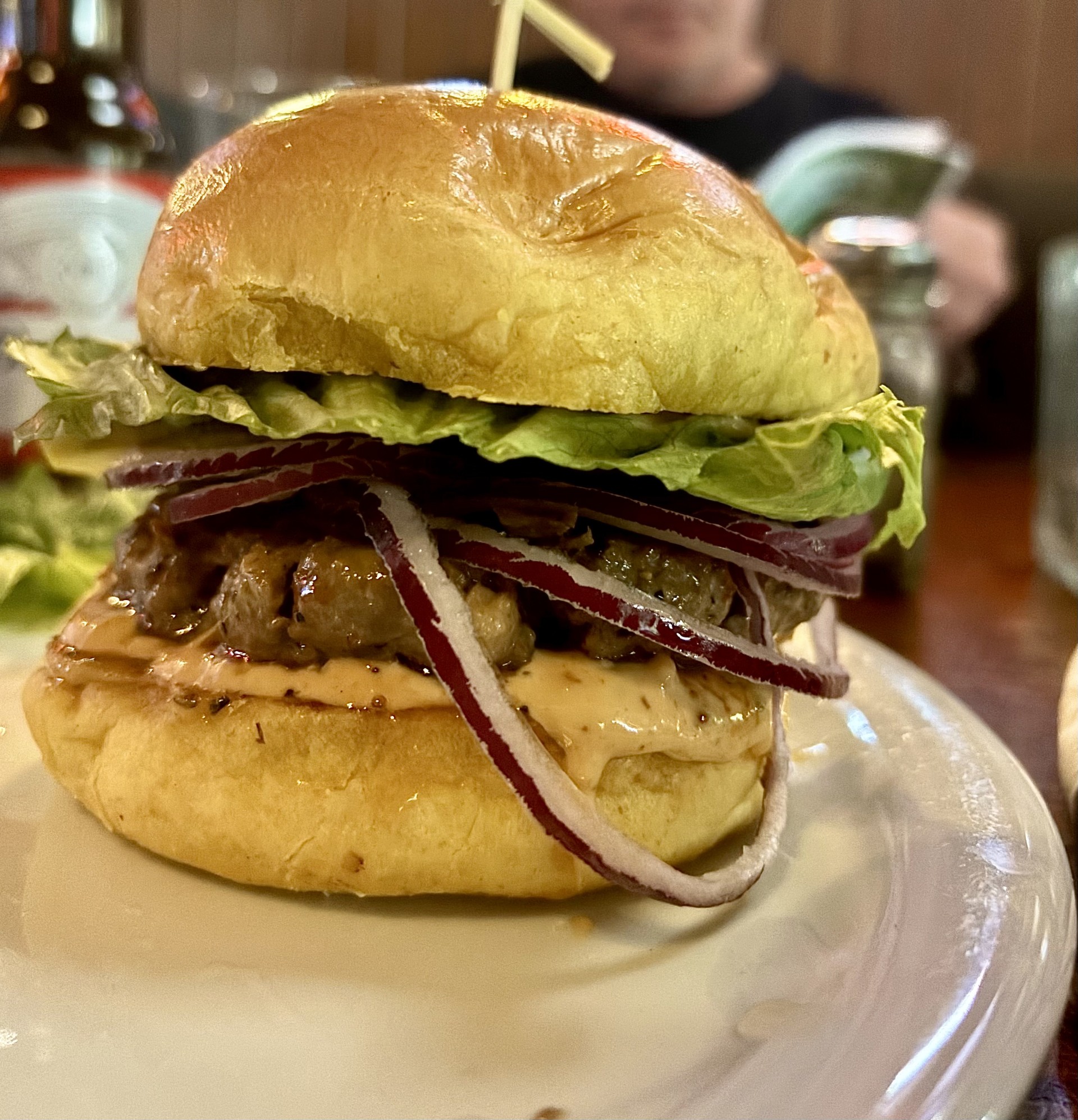 A beef burger that features a juicy ground bison patty paired with tender, smoky pork belly, all drizzled with our homemade honey chipotle sauce. Nestled in a soft brioche bun with crisp lettuce, juicy tomato, and red onion, it’s finished with a mouthwatering smoky baconnaise sauce.